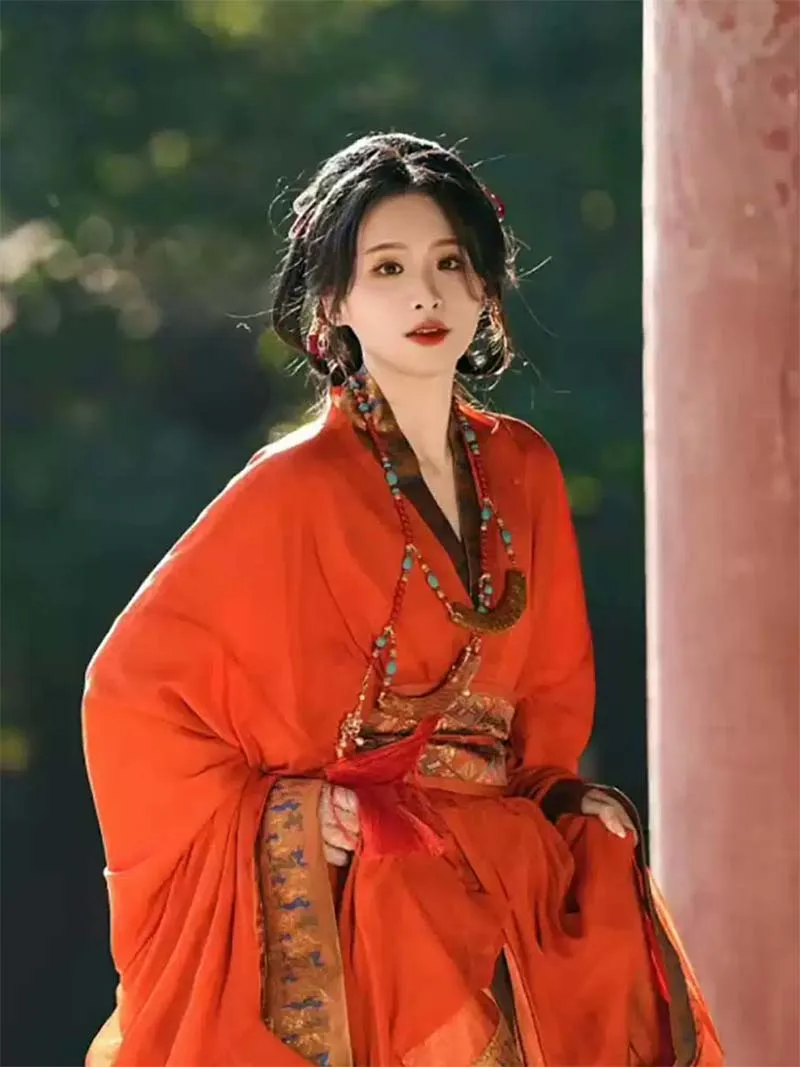 Red Chinese hanfu dress with trailing hem inspired by Warring States robe, featuring wide sleeves and traditional elegance