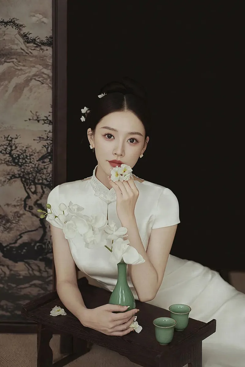 Qipao elegance captured in soft light, revealing the timeless grace of Chinese femininity.