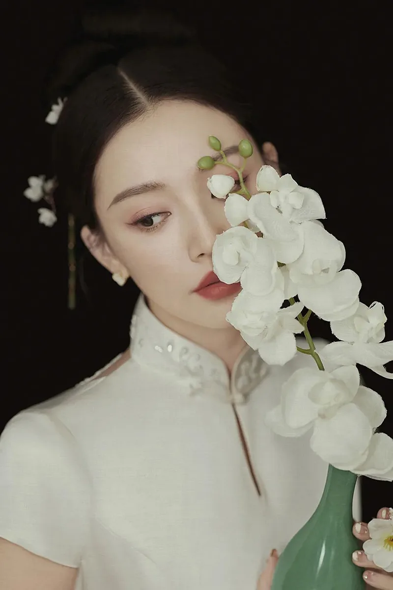 Qipao elegance captured in soft light, revealing the timeless grace of Chinese femininity.